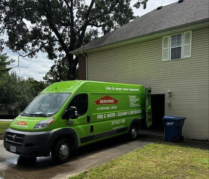 Green van in a driveway.